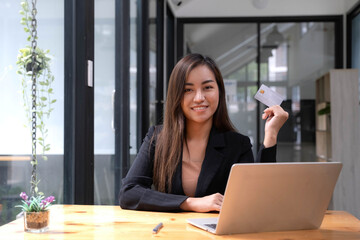 Young Asian business woman using smartphone and credit card for online shopping. Online Payment.