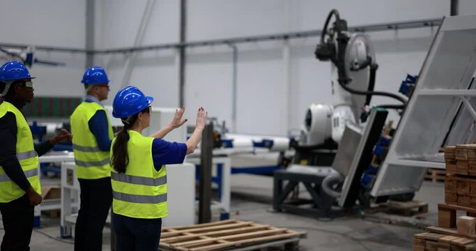 Multiethnic engineers using futuristic augmented reality glasses inside robotic factory