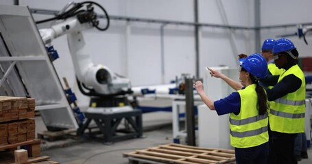 Multiethnic engineers using futuristic augmented reality glasses inside robotic factory - Powered by Adobe