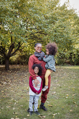 Black mother standing with son and daughter at park in fall	
