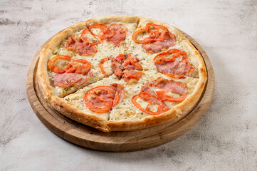 Fresh tasty pizza with meat, sausages, salamy and ham on white concrete background
