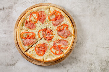 Fresh tasty pizza with meat, sausages, salamy and ham on white concrete background