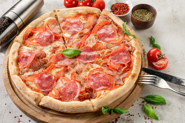 Fresh tasty pizza with meat, sausages, salamy and ham on white concrete background