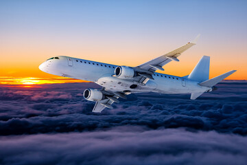 White passenger aircraft fly in the sunset sky