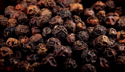 Black pepper grains as background close up