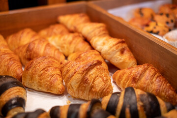 Fresh croissants in a wooden tray in a café