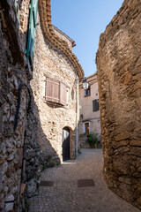 Fototapeta na wymiar Street of Tourtour with Stone houses topped with round tiles, a very touristic village in South of France. Tourtour nicknamed is “The village in the sky of Provence”