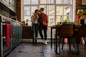 Young multiracial couple embracing in their first home together