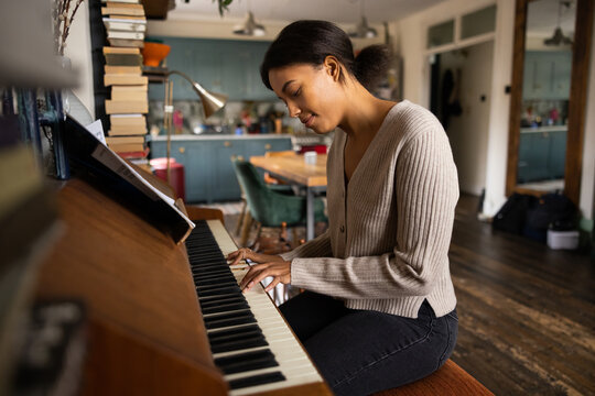 Young African American Female Playing Piano At Home