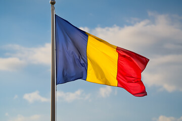Flag of Romania winding against blue sky background with white clouds. Concept image to represent Romania.