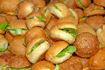 large group of small breads stuffed with chicken and green lettuce leaves