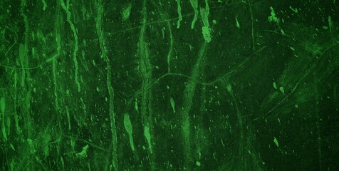 A textured green grunge background with dark patches and rough surface