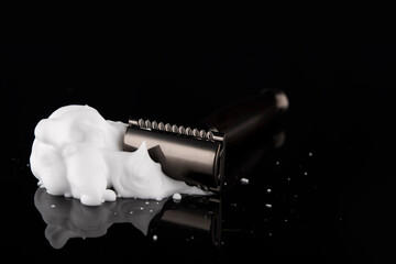 vintage razor in  foam with reflection on a black background. Space for text