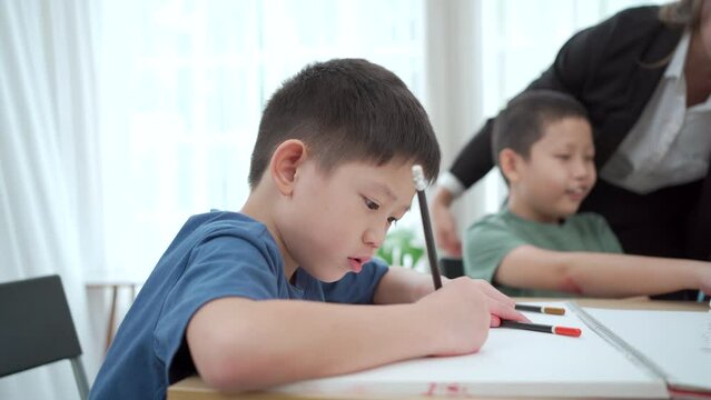 Kindergarten children enjoy drawing and painting in classroom.