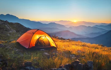 Wall murals Camping tourist tent camping in mountains at sunset
