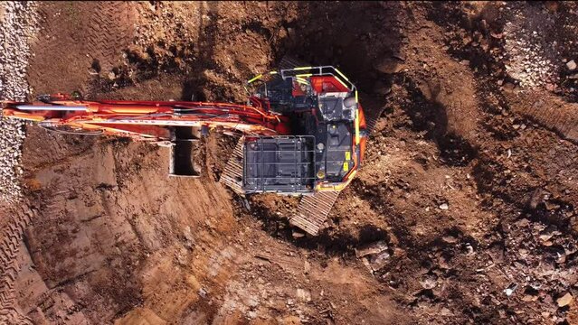 Excavator filling bucket with semi-dry concrete on construction site Excavator filling bucket with semi-dry concrete on construction site Aerial shot	