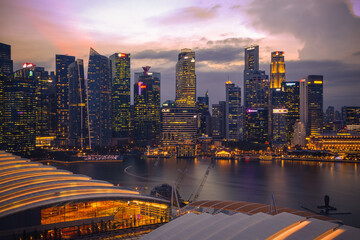Illuminated Singapore cityscape financial centre by Marina Bay during sunset