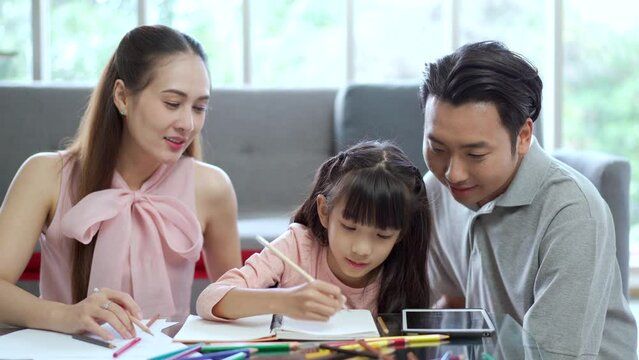 Parent teaching a homework for their daughter at home.