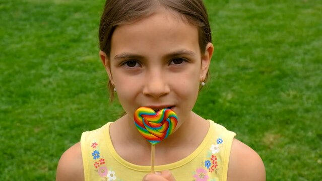 The child eats a lollipop candy. Selective focus.