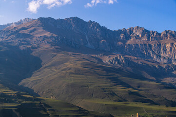 Autumn landscape in the mountains. Mountain peaks with white clouds in the sky. Mountains of North Ossetia. Mountain gorges. View of the mountain peaks. Nature in the mountains.