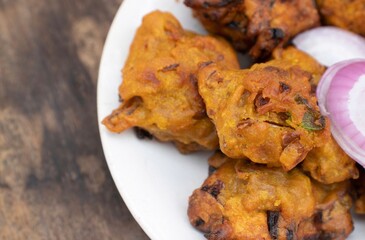 Closeup of Masoor Dal Pakoda or Red Lentil Vada in a Plate Isolated on Wooden Background
