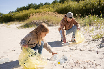 happy family activists collecting plastic waste on beach. Volunteers help to keep nature clean up...