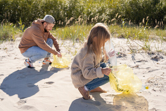 Happy Family Activists Collecting Plastic Waste On Beach. Volunteers Help To Keep Nature Clean Up And Pick Up Garbage. 