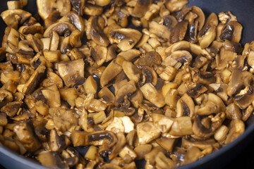 Fragrant homemade fried mushrooms in a frying pan, selective focus. Cooking homemade food