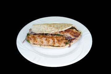 Chicken Adana in Cypriot pita bread in a white plate on a black background