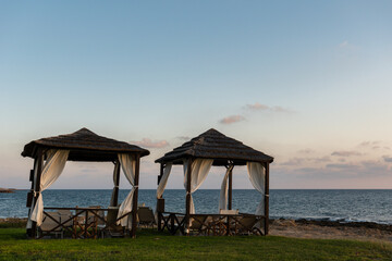 view to wooden beach cabanas with sea in a background