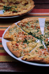 Flammekueche, tarte flambée coupée en morceau sur une assiette