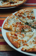 Flammekueche, tarte flambée coupée en morceau sur une assiette