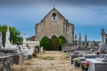 Schöner alter Friedhof mit Gräbern, Kapelle, Kreuz und Glocke in West Frankreich