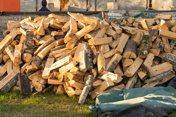 A big mountain of chopped wood for the stove. A big pile of firewood for ignition. Harvesting wood for heating for the winter in the village