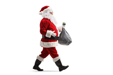 Full length profile shot of santa claus walking and carrying a plastic bin bag