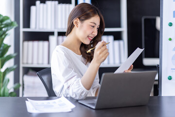 Young business Asian woman working in note and tablet the home workplace, reading and taking notes on the paper, accounting, tax, Financial, Business concept
