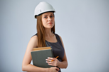 Serious engineer woman in white construction hardhat inspecting a construction firm. Isolated female worker portrait.