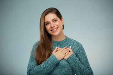 Smiling woman in green sweater holding two hands on chest. Advertising female studio portrait.