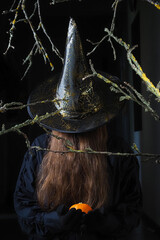 Mysterious stranger in halloween hat on dark background