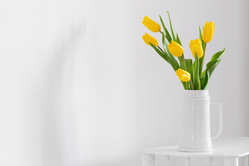 yellow tulips in vase on white background