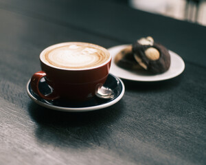 Latte coffee and cookies by window light.