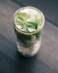 Close up of an iced matcha latte in a cafe.