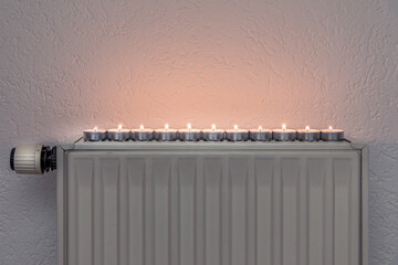 Tea candles on a wall heater, concept of alternative heeating possibilities during the energy...