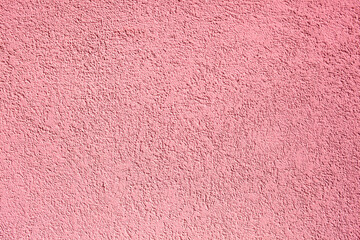Background of pink concrete wall. Decorative embossed concrete and glue plaster. Pink plastered wall. Plaster textured background. Blurred photo