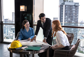 Handsome engineer man discuss with two architect teammates about project on high office  building 