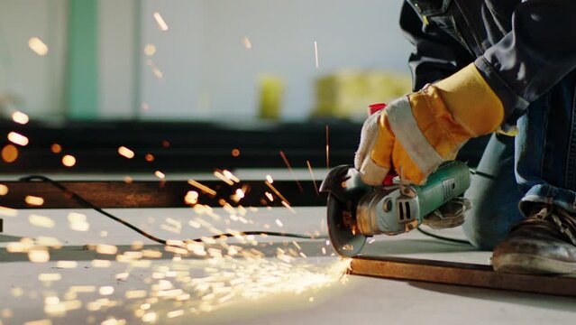 Concept of construction site and working closeup in front of the camera creating sparks by disc welding machine