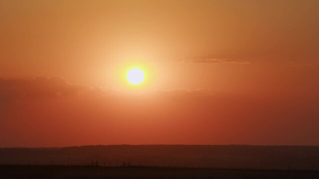 Awesome epic cloud space. Big red hot sun in warm air distortion above horizon. Timelapse.