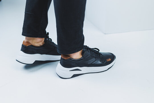 Men's legs in casual shoes of black color made of genuine leather, men on shoes in black sneakers. High quality photo