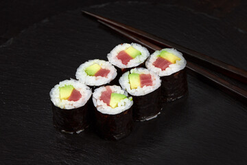 Set of tuna sushi rolls on black desk background