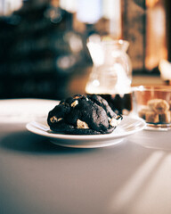 Fermented black garlic chocolate chip cookie in cafe window light.